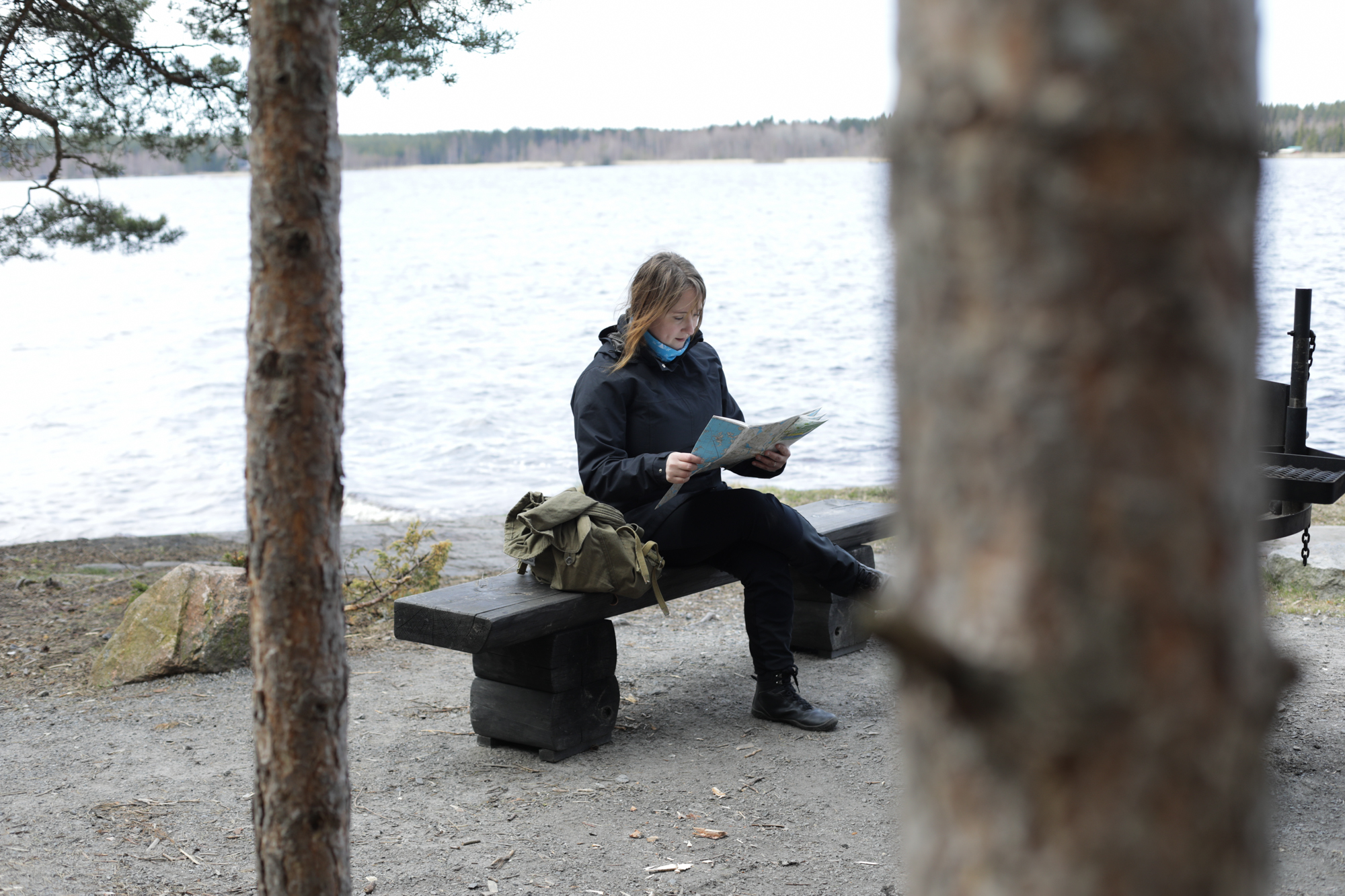 Anne-Mari lukee karttaa meren rannassa.