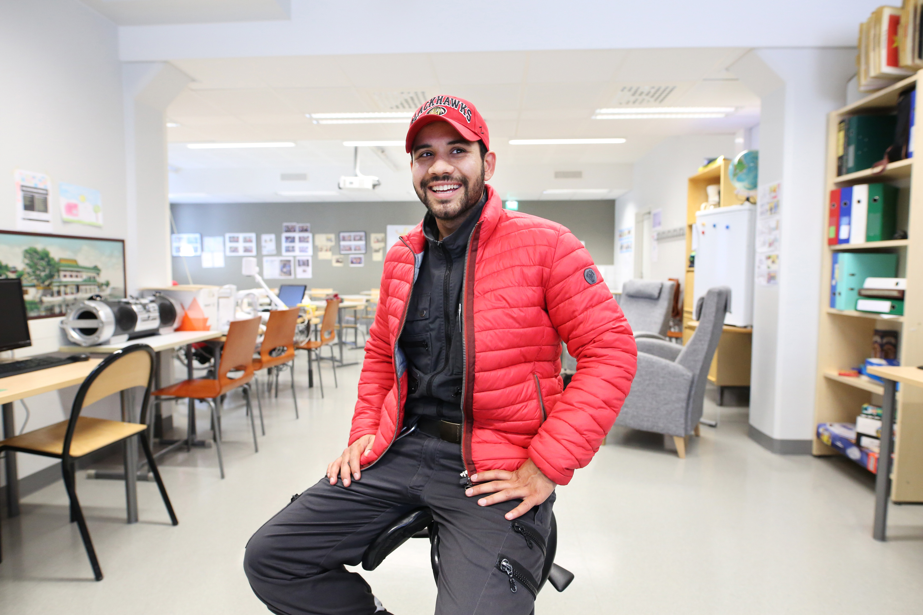 Mohammad Hoseini istuu VALMA-opintojen luokkatilassa, ympärillä näkyy pulpetteja ja muita huonekaluja.