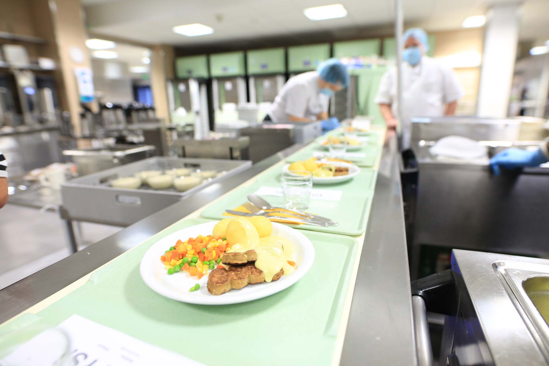 Kuvassa Soiten ruokapalveluiden ruoka-annokset kulkevat hihnalla.