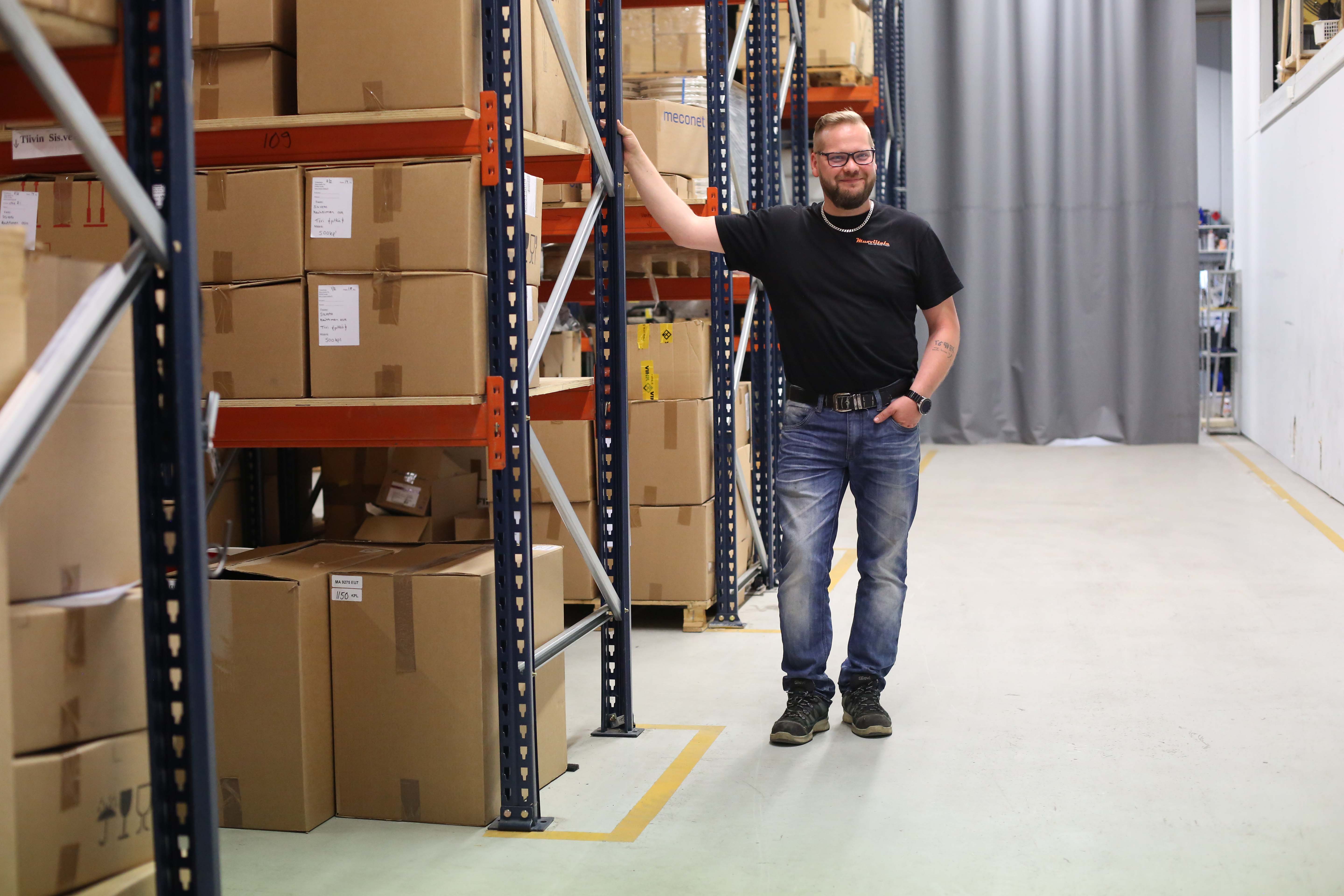 Antti Viitala poseeraa muovialan yrityksen varastotilassa.