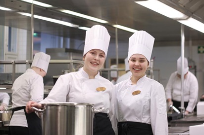 Opiskelijat hymyilevät keittiössä