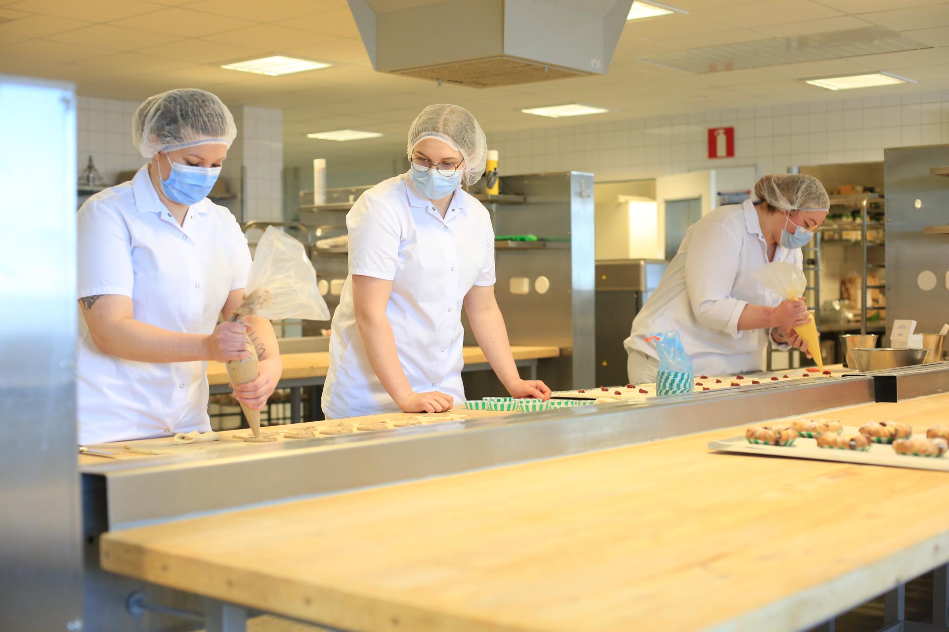 Leipuri-kondiittoriopiskelijat työssään työsalissa.