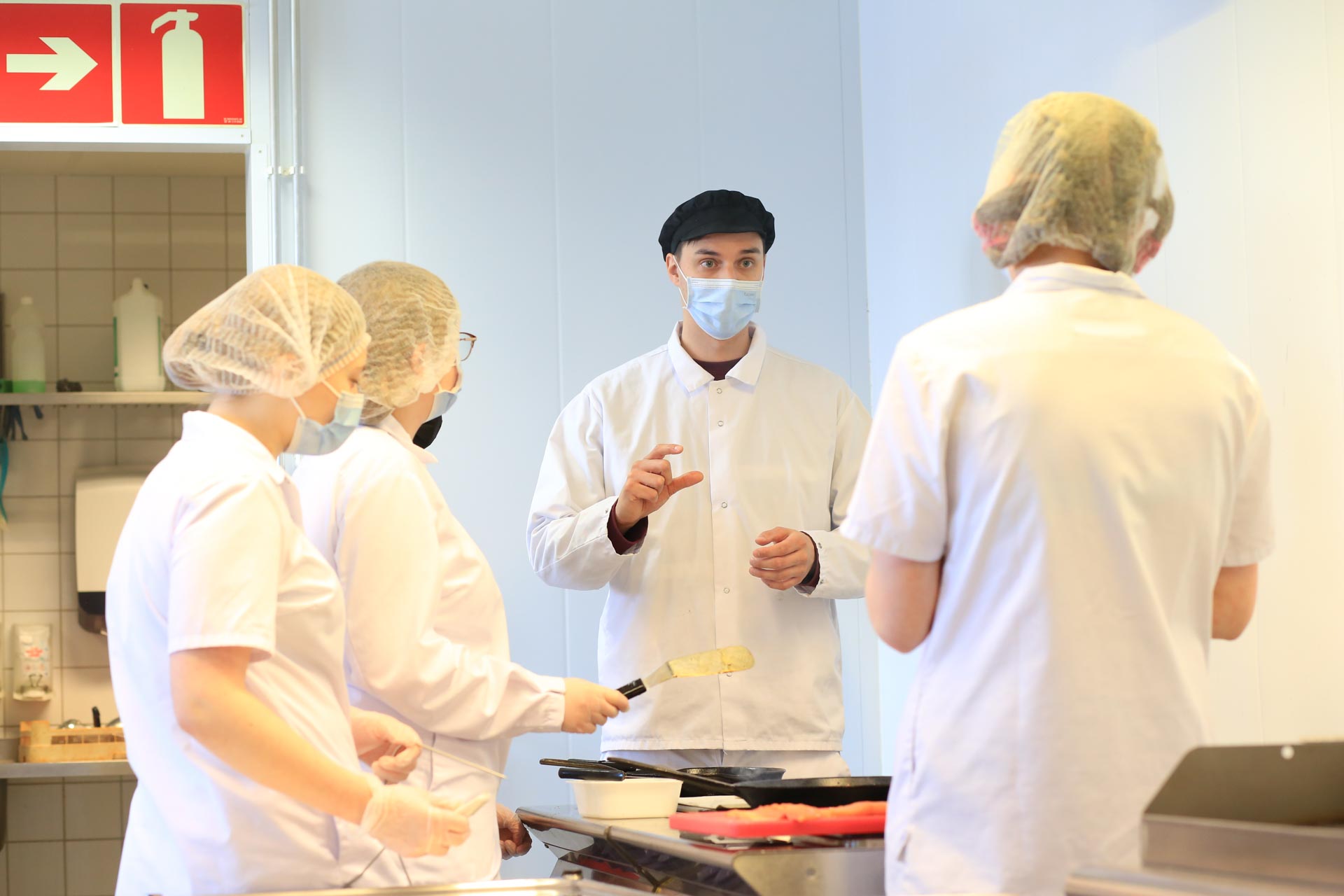 Kuvassa elintarvikealan opettaja Tom Annala ohjeistamassa opiskelijoita. 