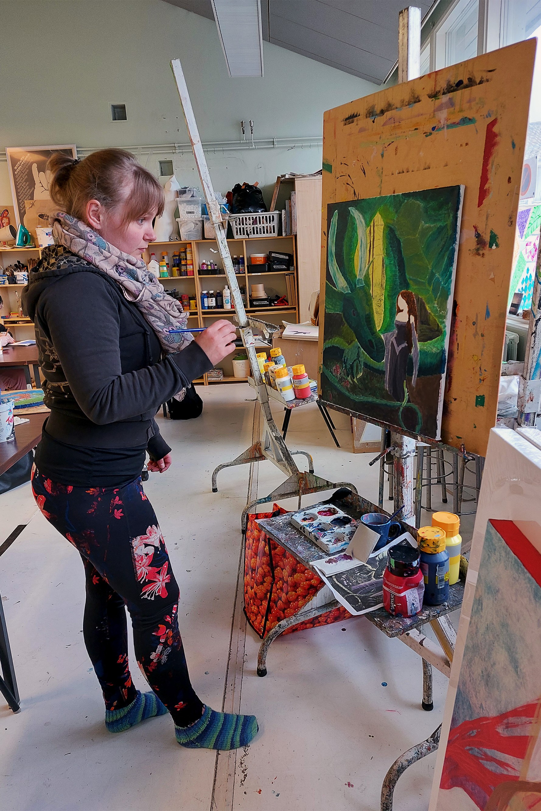 Opiskelija studiossa maalaamassa fantasia sävytteistä työtä