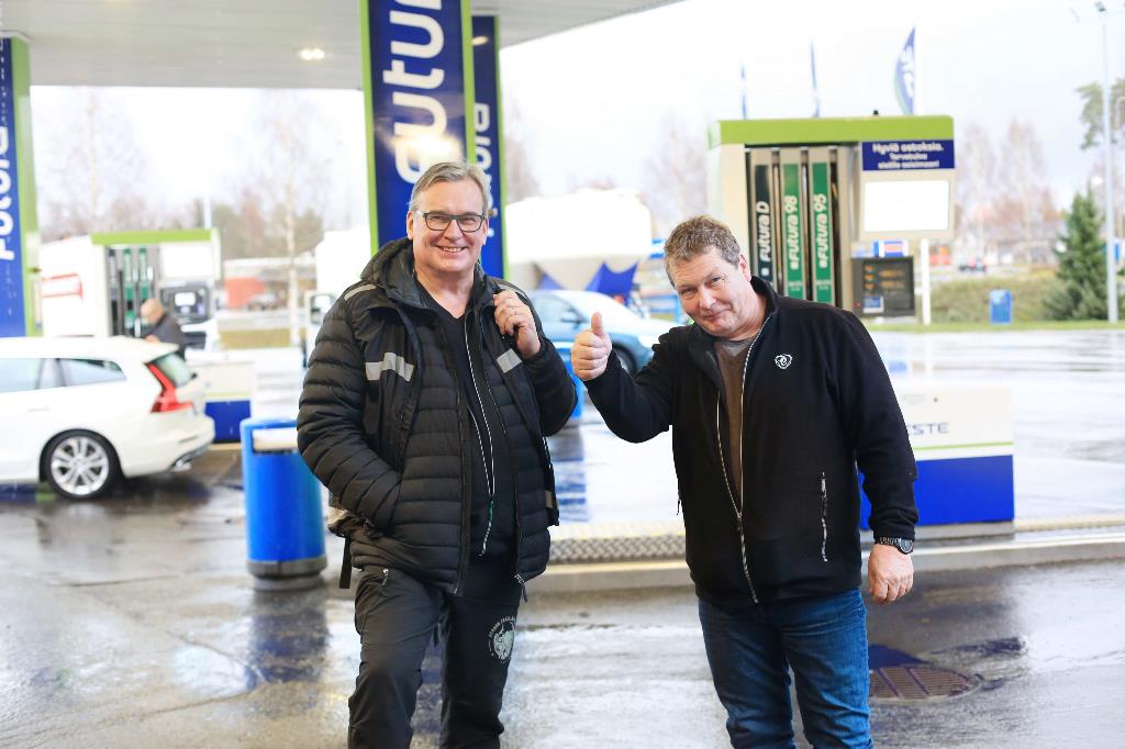 Kuvassa kuljetusalan yrittäjä Jorma Möttönen poseeraa peukkua näyttäen huoltoasemalla. Vierellä kpedun projektipäällikkö Jorma Koivuniemi. 