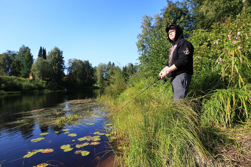 Metsäkoneenkuljettajaksi opiskeleva Verneri Santapakka nauttii kalastamisesta. Kuvassa hän kalastaa kesämaisemissa koulun viereisellä joella.