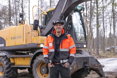 Tuomas Kero kaivinkoneen edessä.
