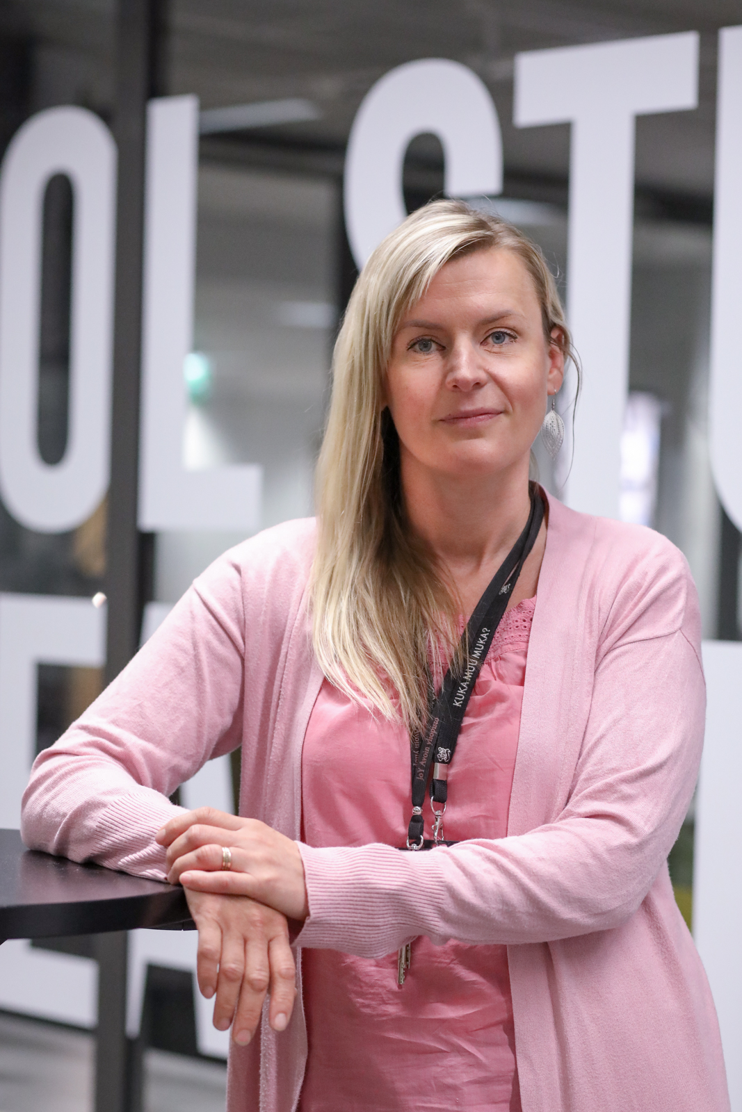 Kuvassa oppisopimuspäällikkö Johanna Herrala nojaa kaiteeseen ja poseeraa kameralle.