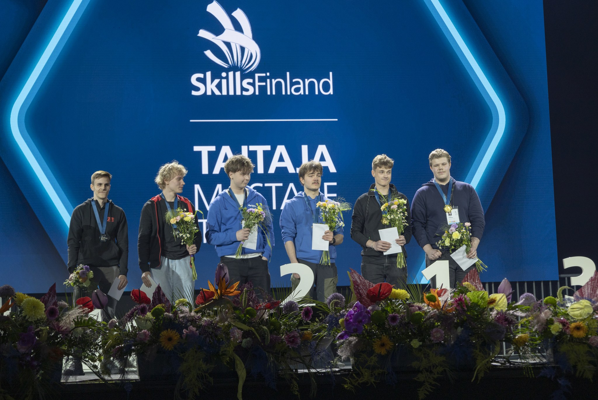 Kappaletavara-automaatiolajin voittajat lavalla.