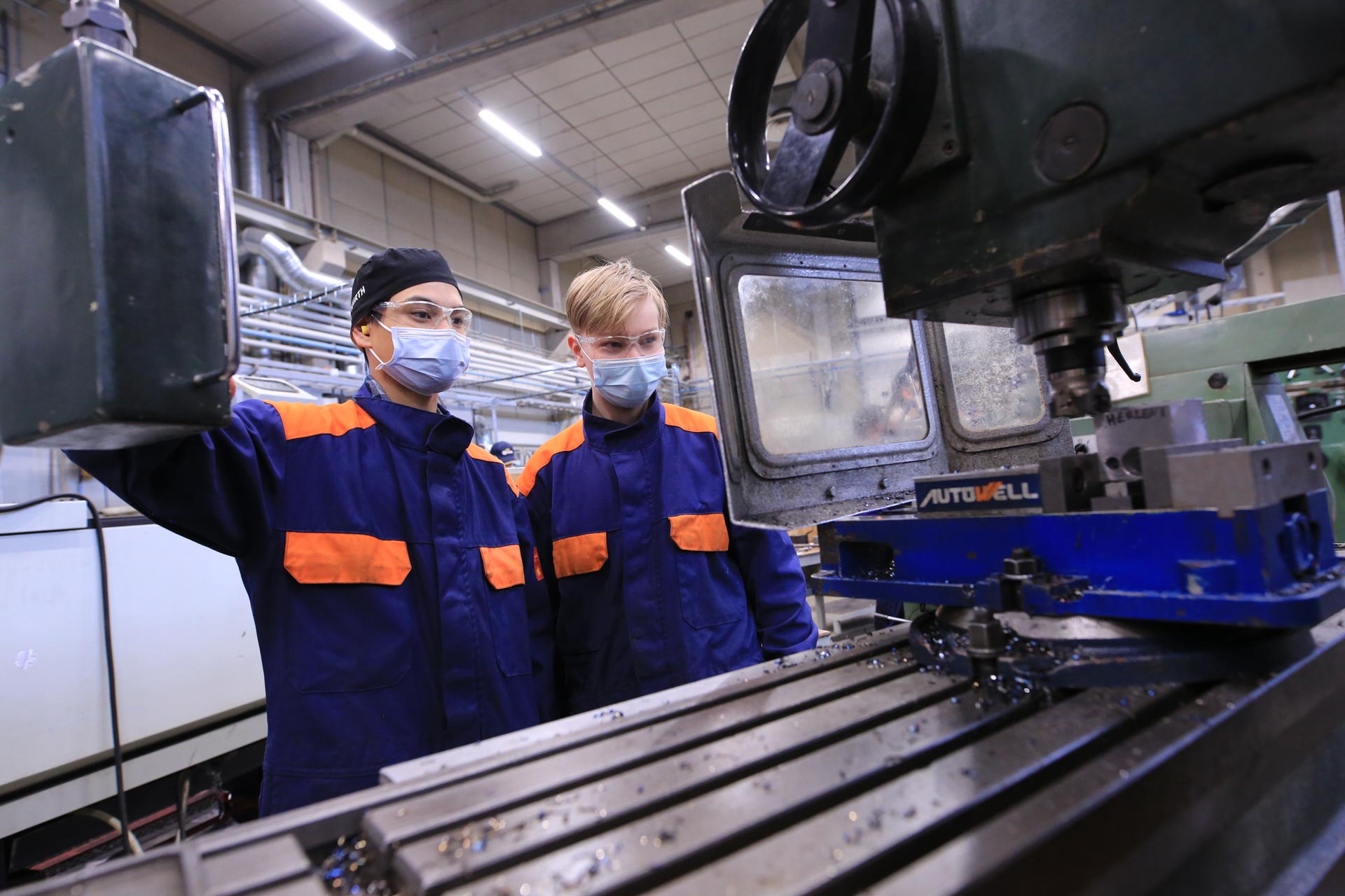 Kone- ja tuotantotekniikan opiskelijat poseeraavat tuotantotiloissa