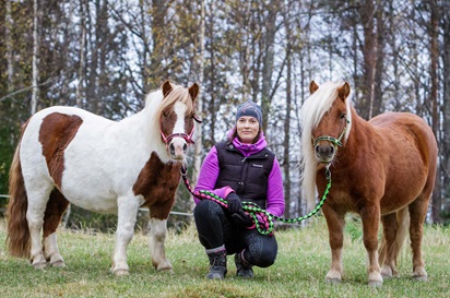 Päivi Kvist poseeraa ponien kanssa kameralle