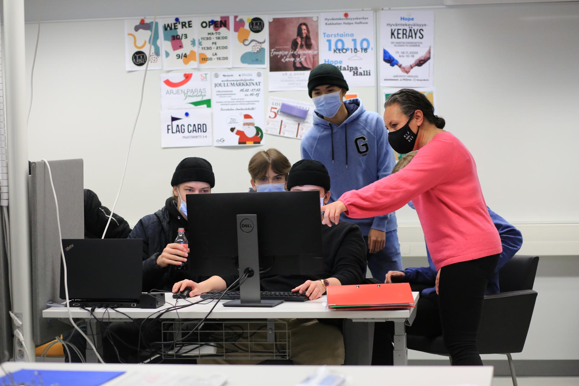 Kuvassa liiketoiminnan opiskelijat työstävät lehtiprojektia istuen ryhmässä tietokoneen ympärillä. 