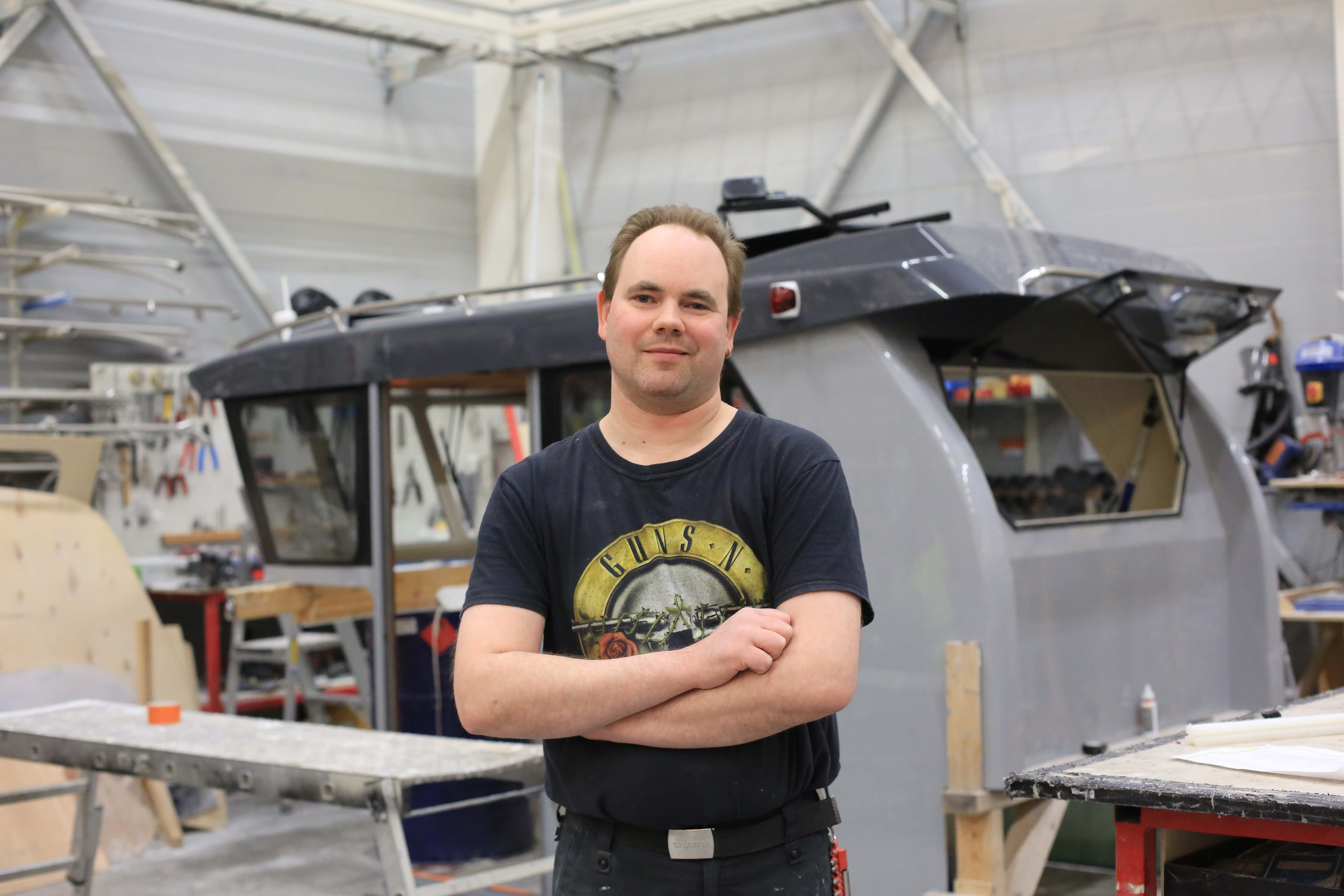 Kuvassa yrittäjä Simon Lindkvist poseeraa tuotantohallissa istuen. 