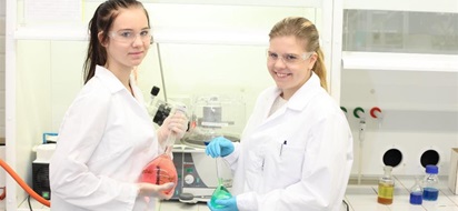 Ronja Sarin ja Nea Pitkäkangas labrassa värikkäät seokset käsissään