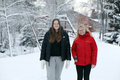 Kuvassa kasvatus- ja ohjausalaa opiskelevat Venla ja Matleena poseeraavat talvisessa maisemassa koulun pihalla.
