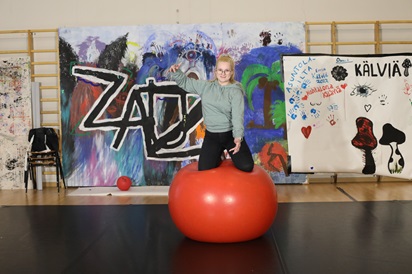 Kuvassa Viia Siurua tasapainoilee ison jumppapallon päällä koulun liikuntatiloissa.
