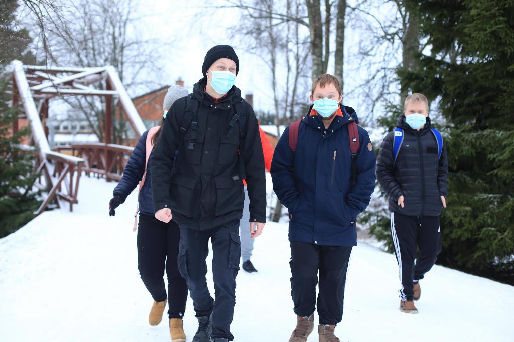 Kuvassa nuoriso- ja vapaa-ajanohjaajaksi valmistunut Valtteri Konttila kävelee erityisryhmän opiskelijoiden kanssa ulkona lumisessa maisemassa. 